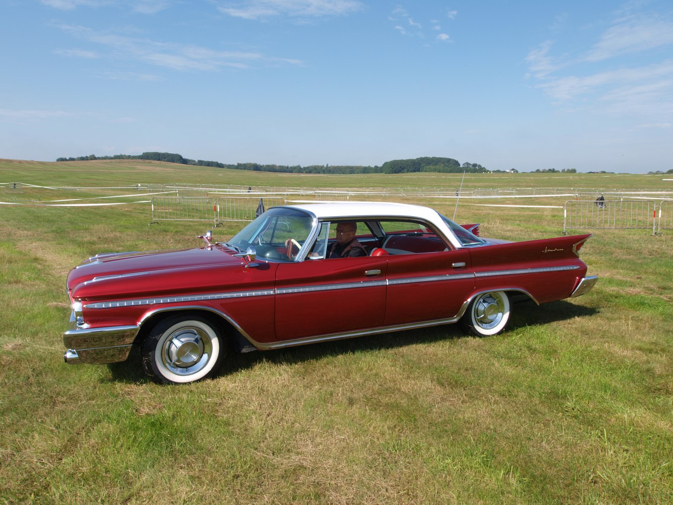 Side profile of a 1960s 4-door hardtop with tailfins and whitewall tires