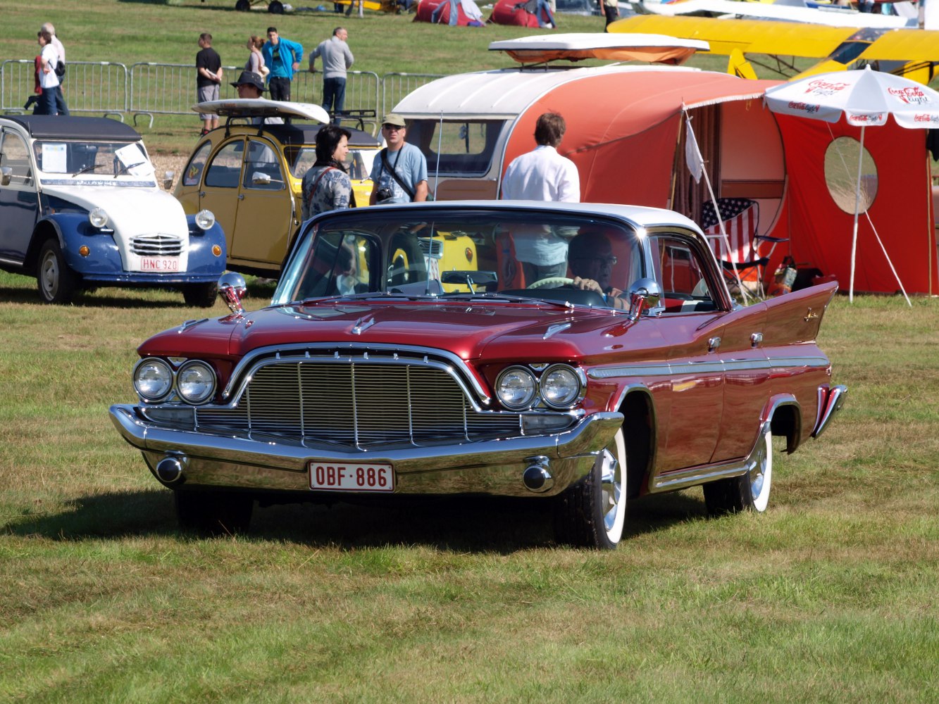 Vintage 4-door hardtop with chrome grille, whitewall tires, and rear fins