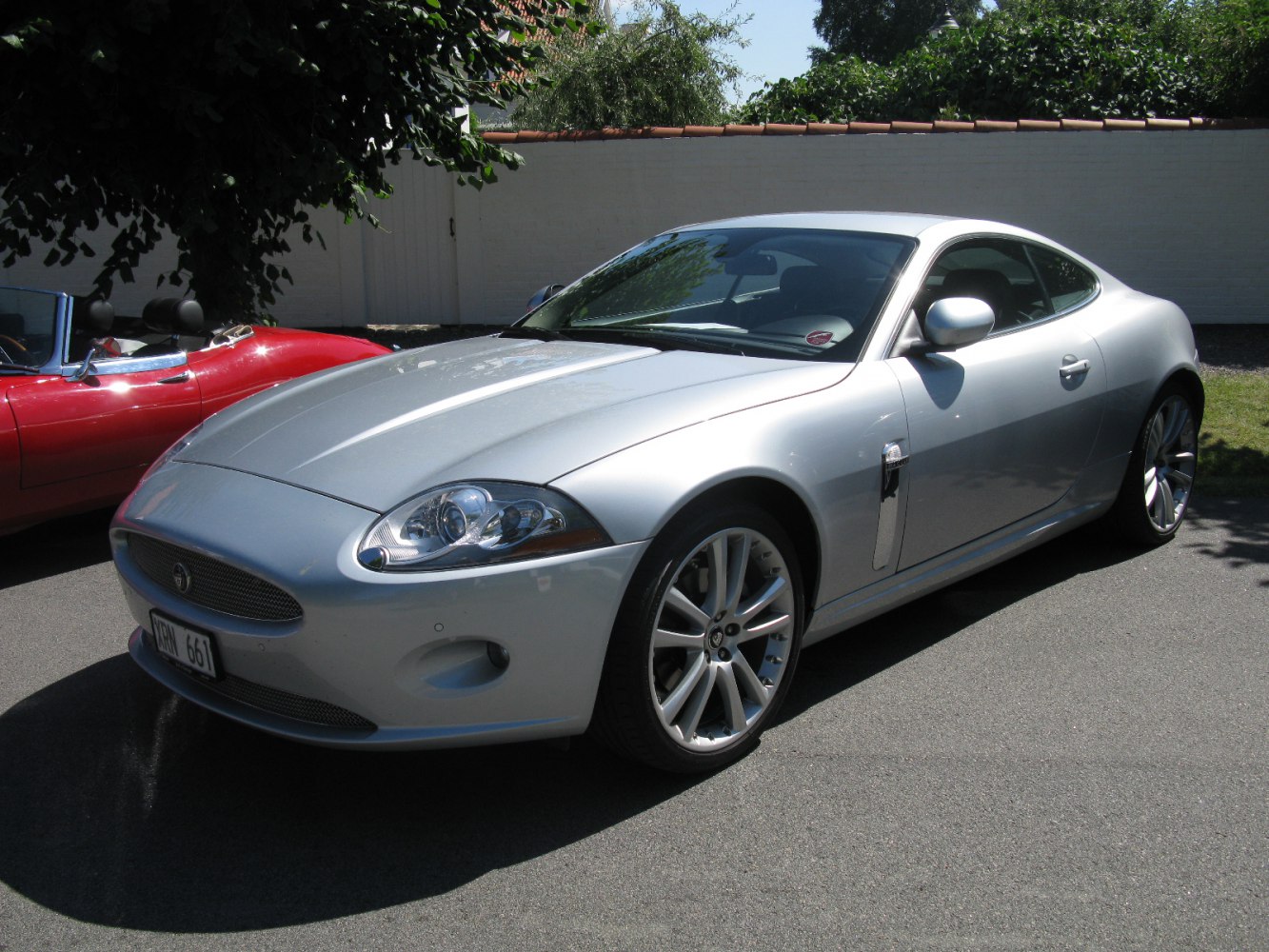 Silver sports coupe front angle showcasing headlights and alloy wheels