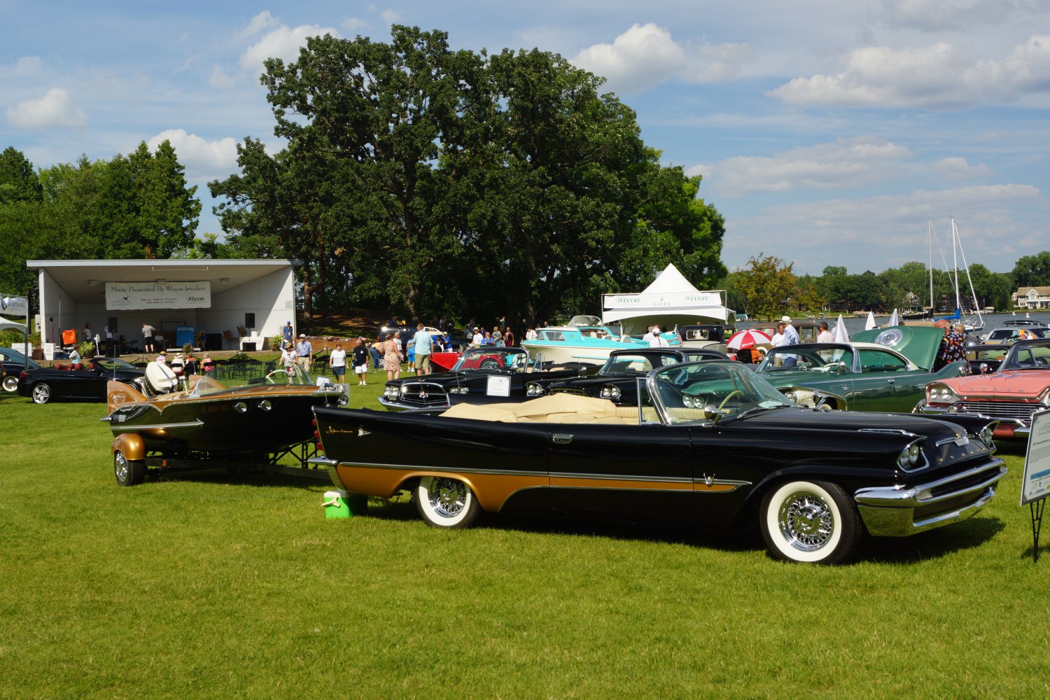 Black and gold vintage convertible with attached retro boat trailer