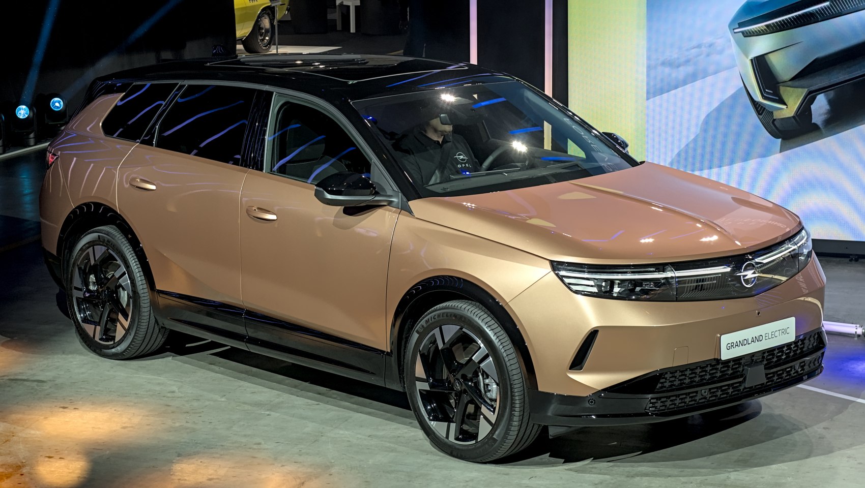 Bronze-black electric SUV front side with LED lights and alloy wheels