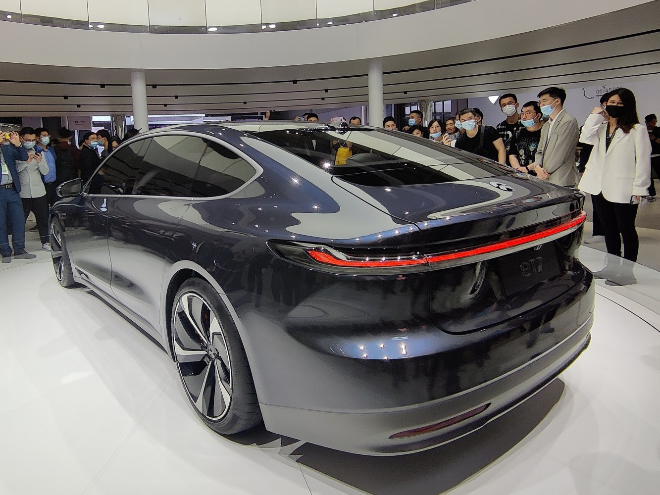 Rear and side view of sleek electric sedan with distinctive taillight and sporty wheels