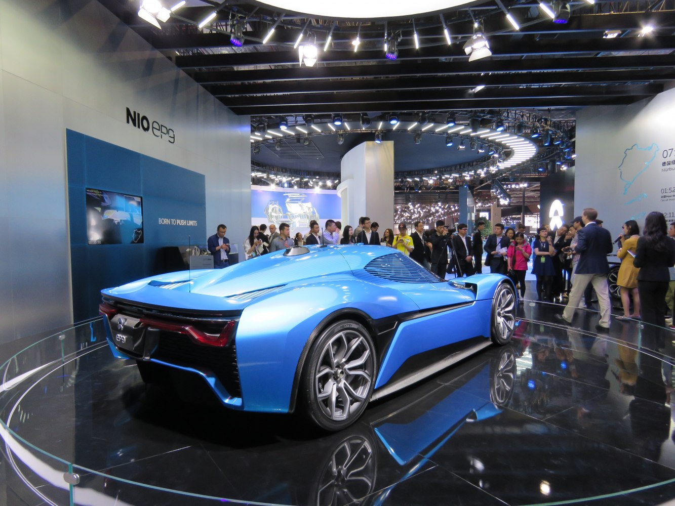 Rear view of a sleek blue electric supercar with aerodynamic design and performance wheels.