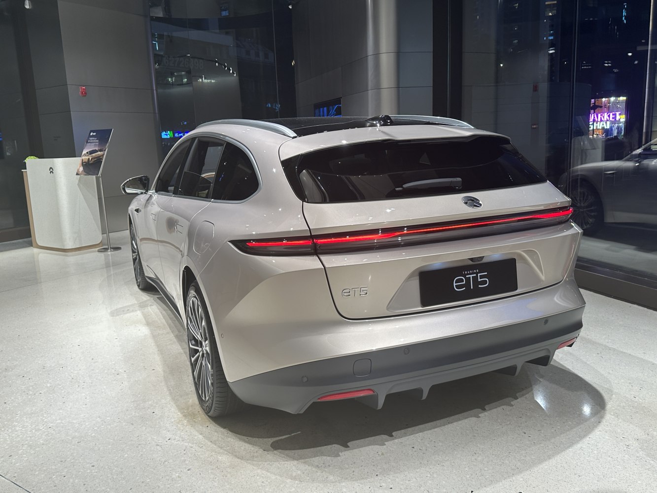 Rear view of electric station wagon with LED light bar and panoramic roof.