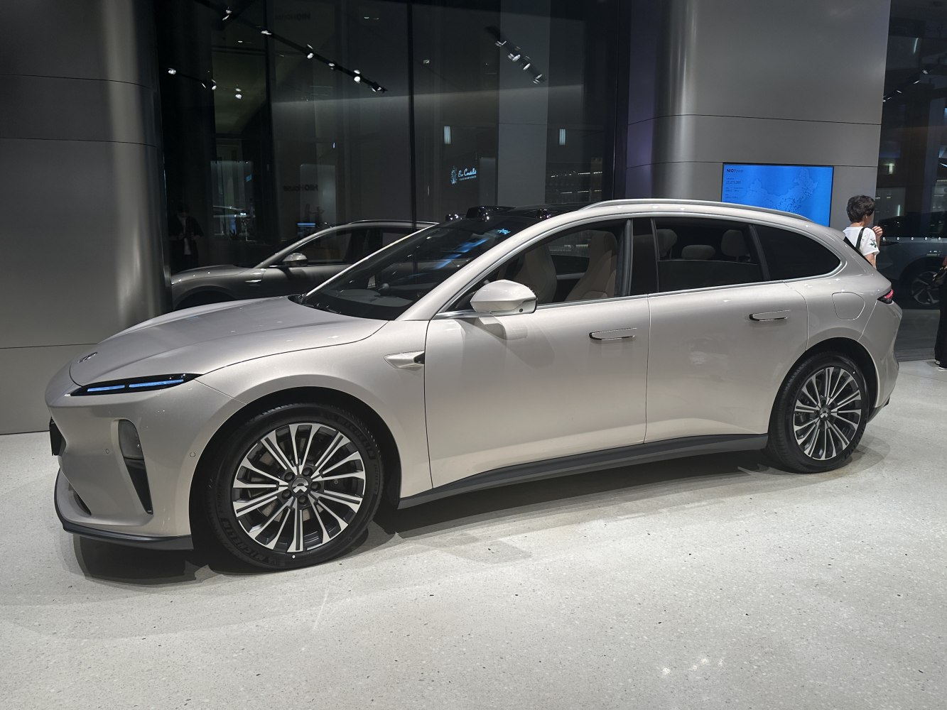 Streamlined electric touring sedan with aerodynamic curves and multi-spoke alloy wheels