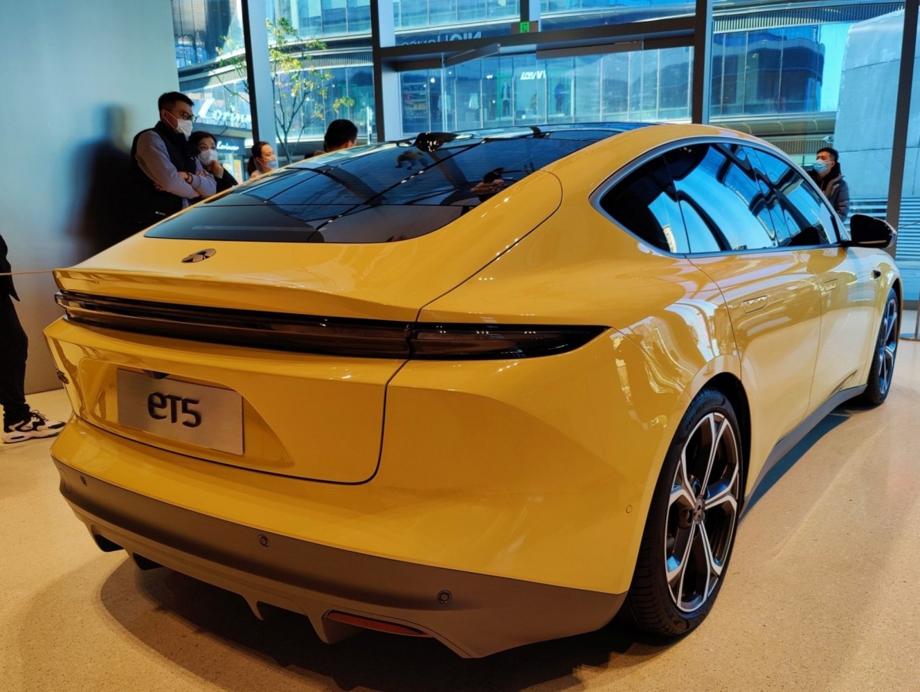 Yellow electric sedan rear with sleek aerodynamic design and modern taillights