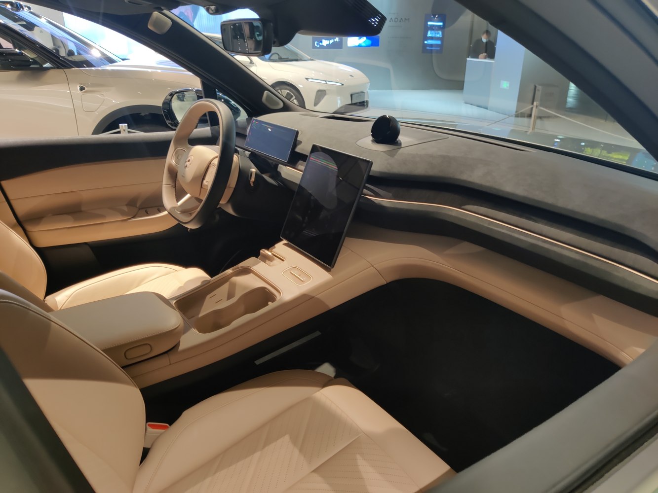 Dual digital displays, beige leather seats, modern dashboard.