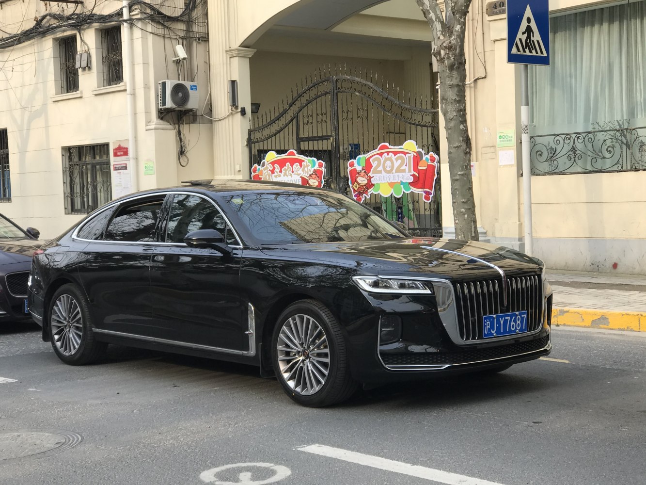 Black luxury sedan with large vertical grille and multi-spoke alloy wheels