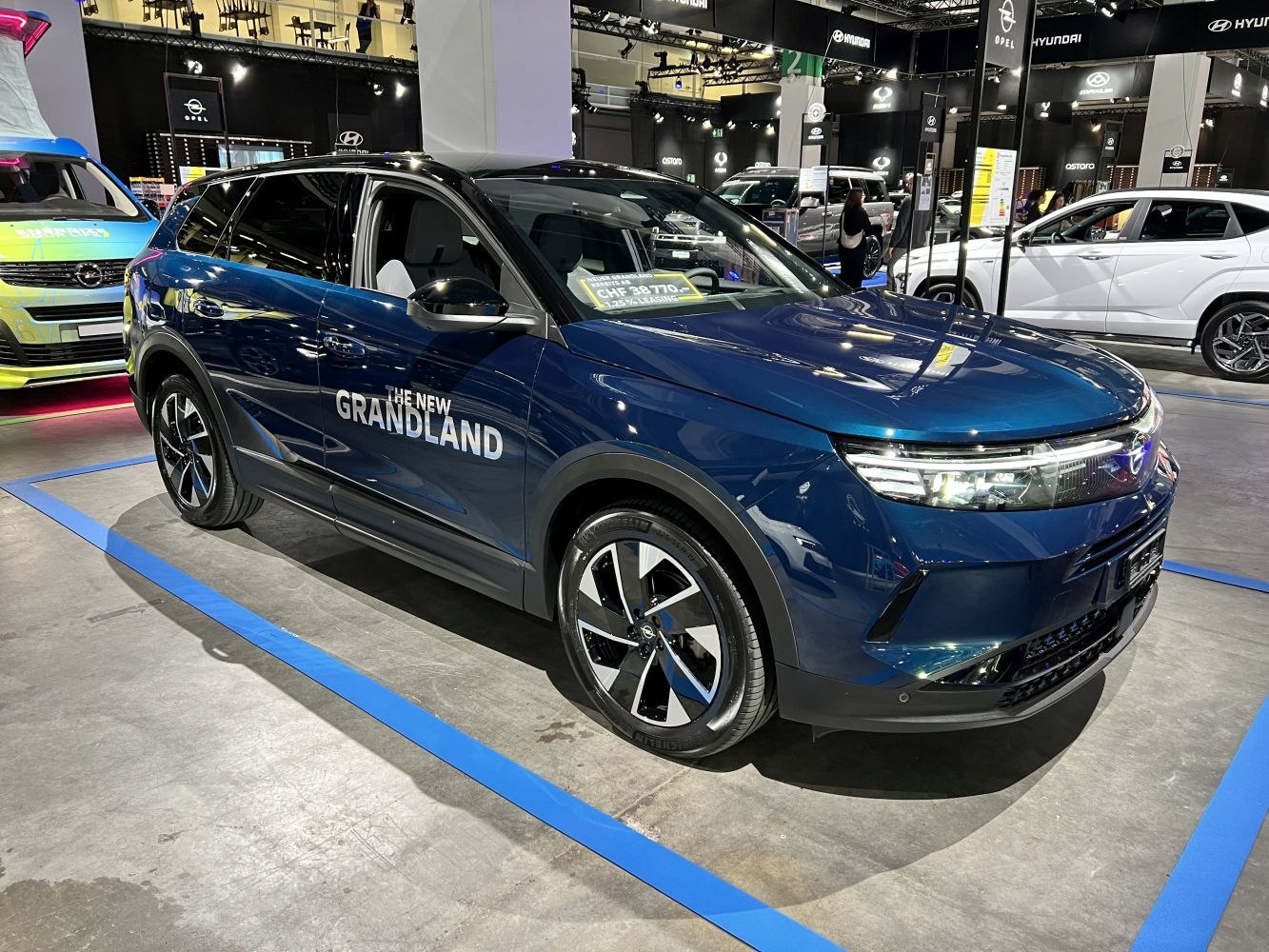 Front side view of a blue SUV with LED headlights and stylish alloy wheels