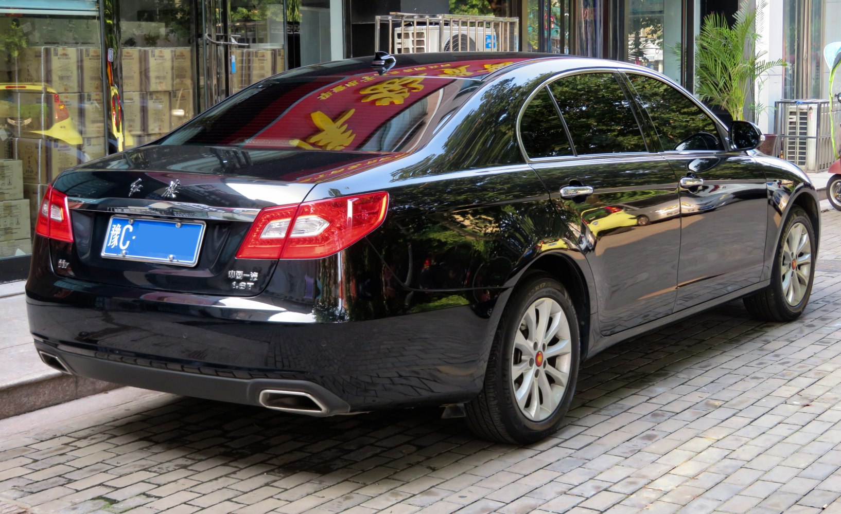 Black sedan rear side with dual rectangular exhaust outlets and tinted windows
