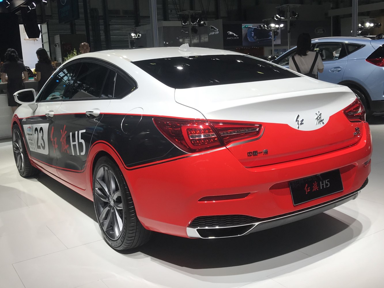 Sporty sedan rear with dual-tone red and white livery and sharp taillights