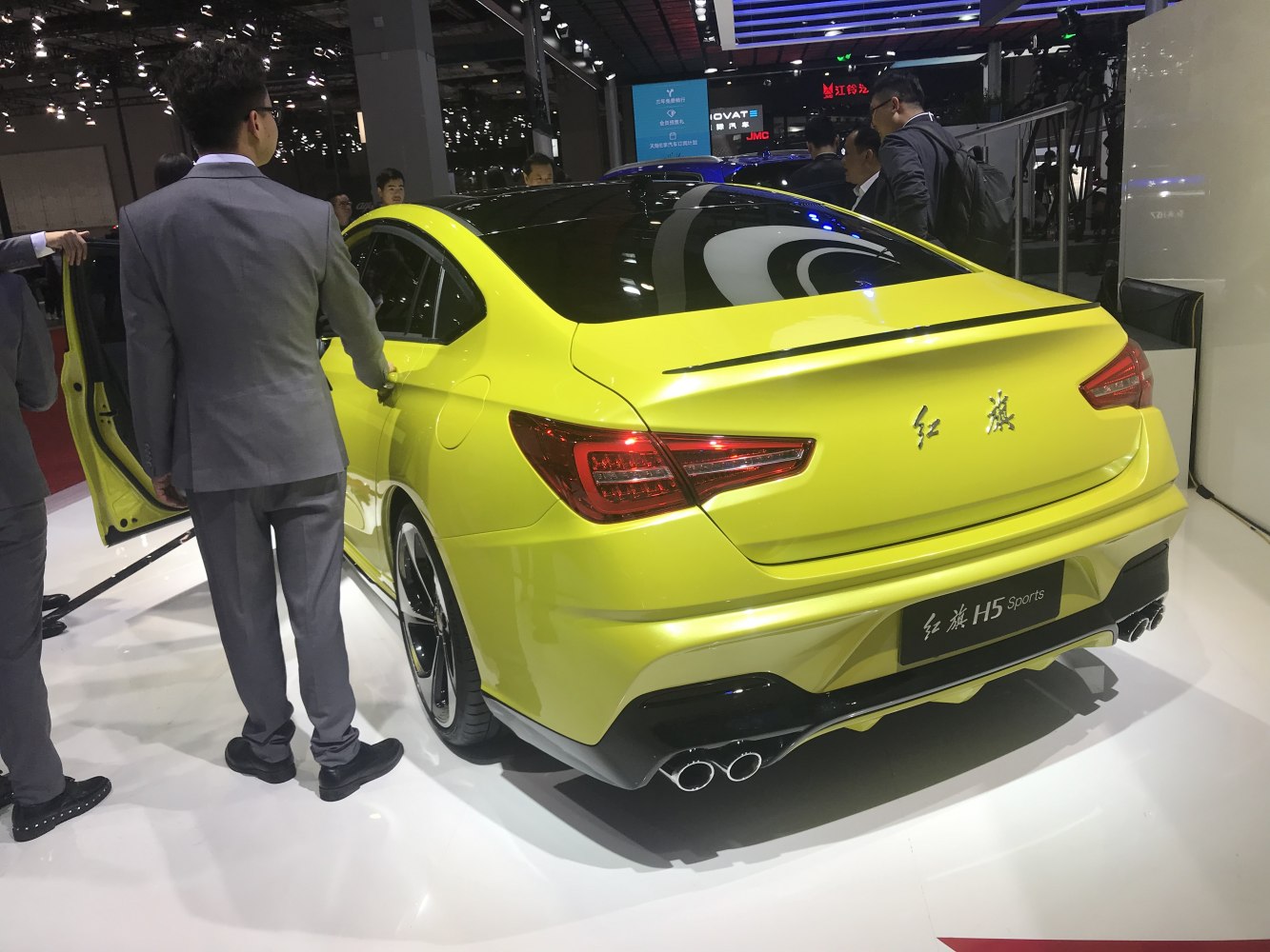 Rear view of a sporty bright yellow sedan with dual exhausts and sleek taillights