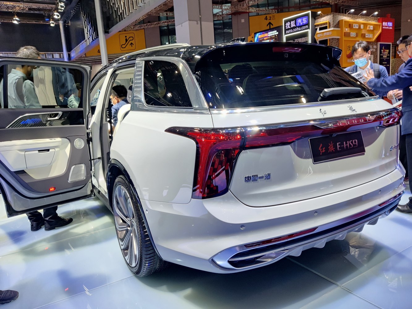 Rear view of electric SUV with LED taillights and open door.