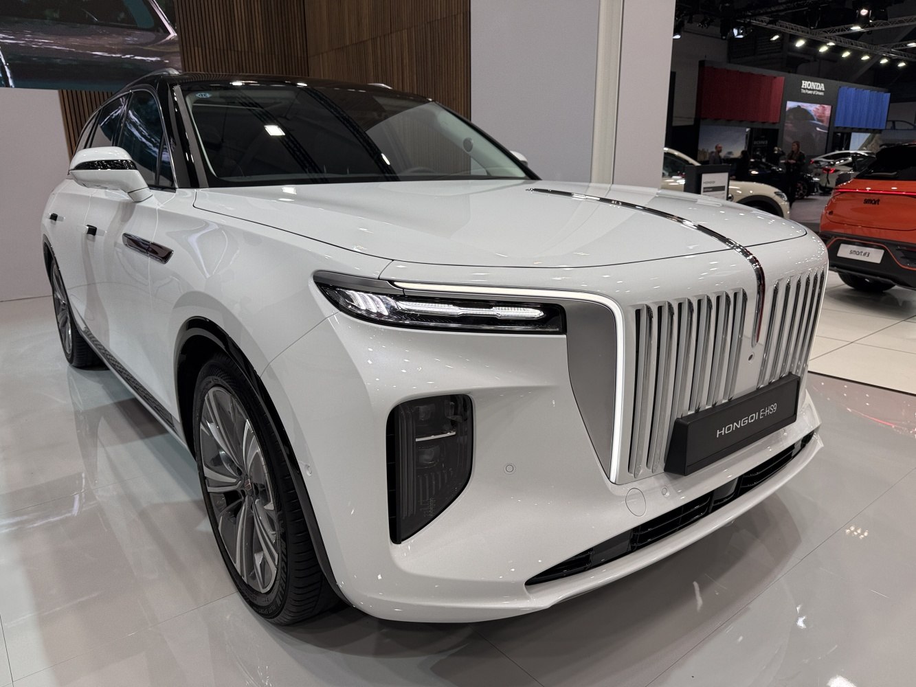 White luxury SUV front with vertical chrome grille and sleek slim headlights