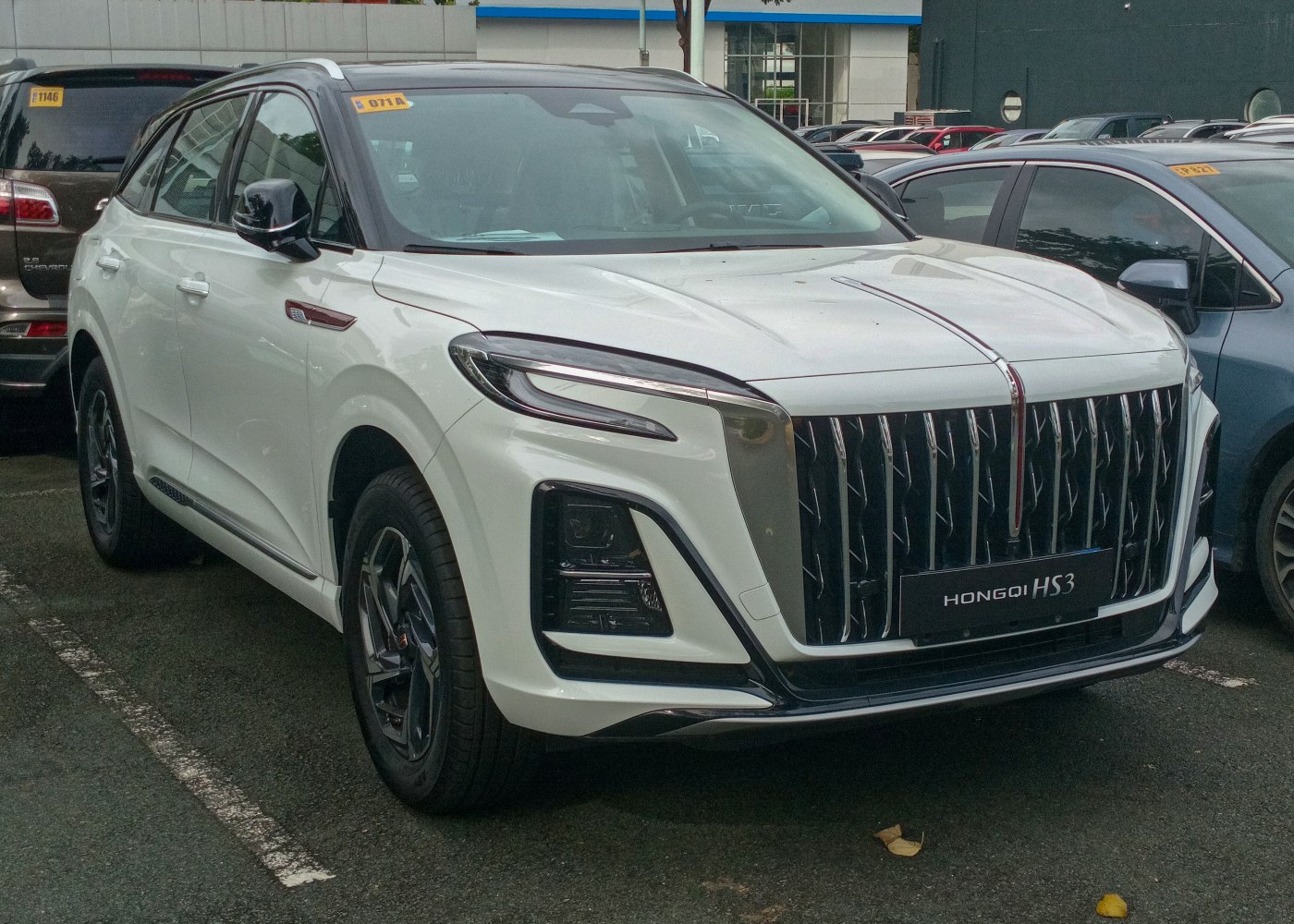 Large vertical grille and sleek LED headlights on white SUV
