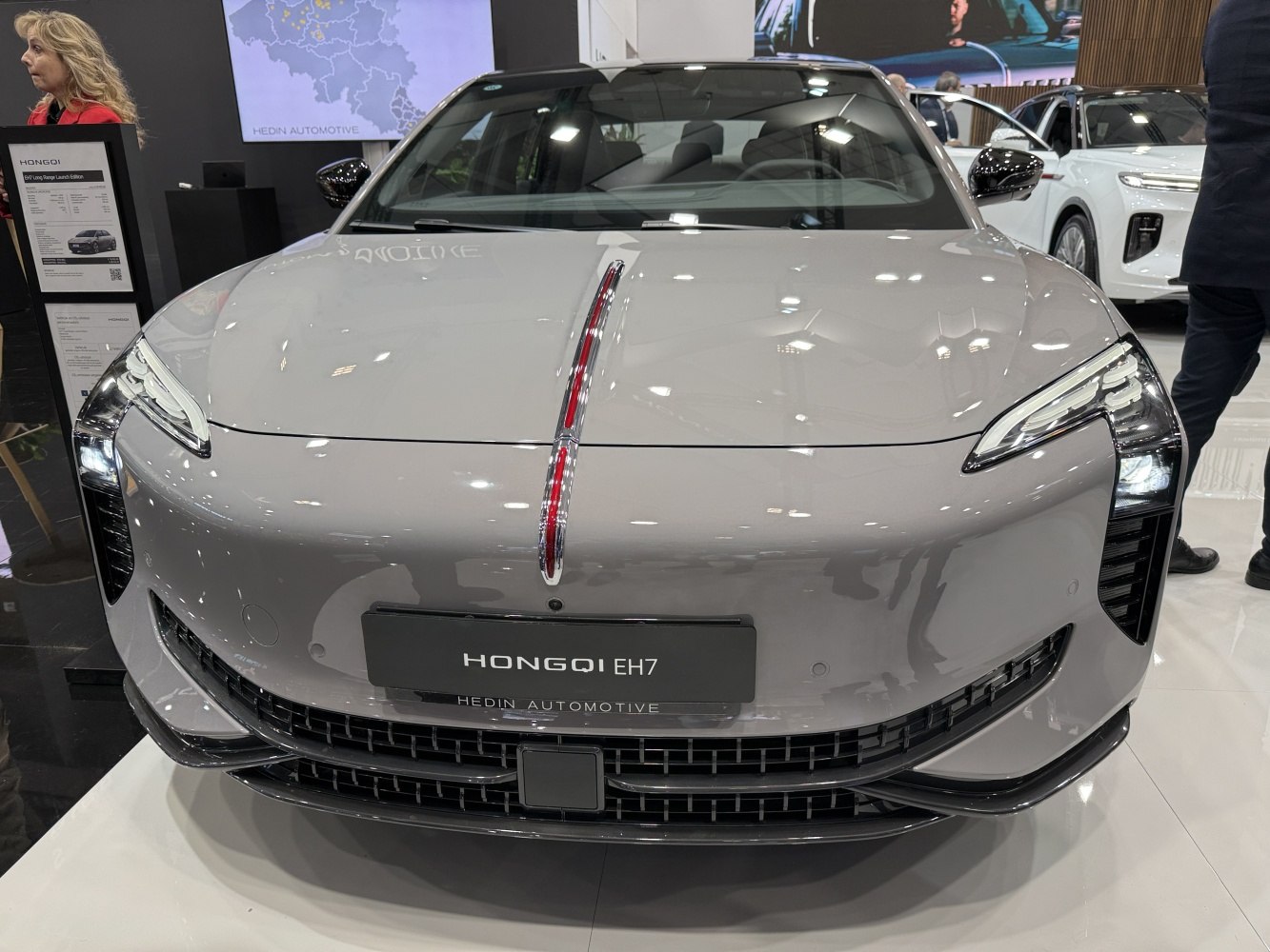 Front view of modern electric sedan with unique LED headlights and vertical light strip