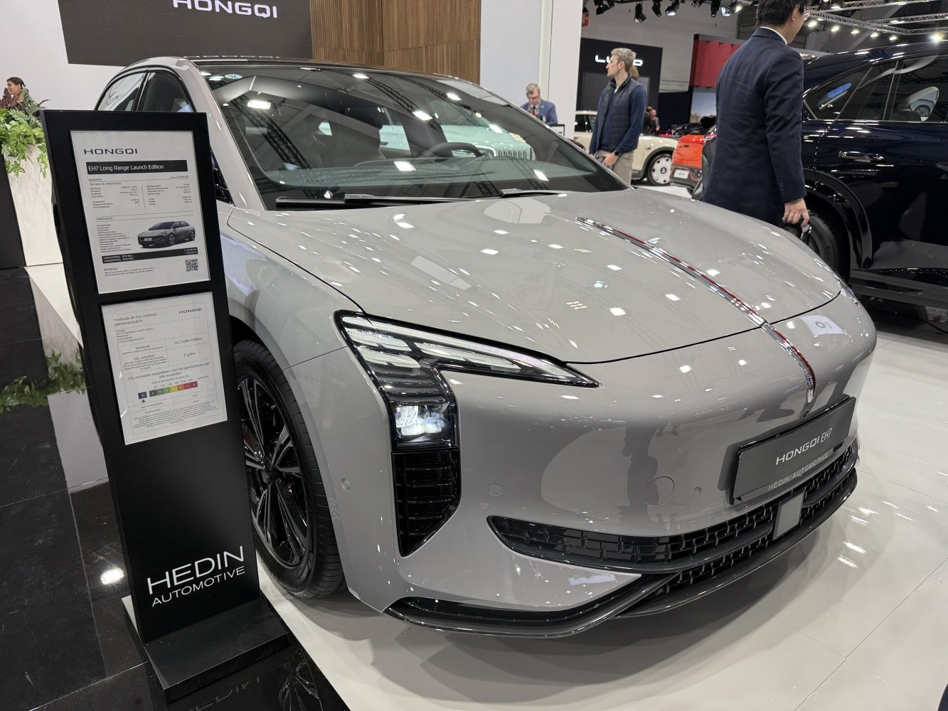 Front of an electric sedan with vertical LED headlights and chrome hood strip