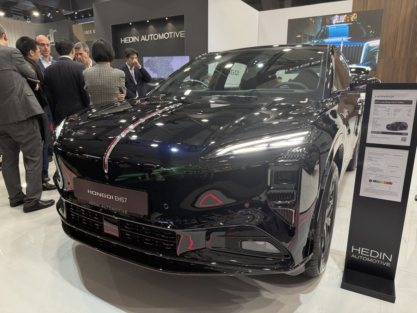 Sleek electric SUV front with sharp LED headlights and chrome hood strip