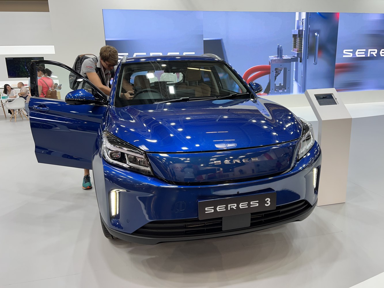 Front view of blue EV with LED headlights and open driver door