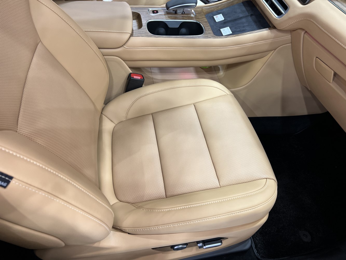 Beige perforated leather seat and wood-trimmed center console with gear selector