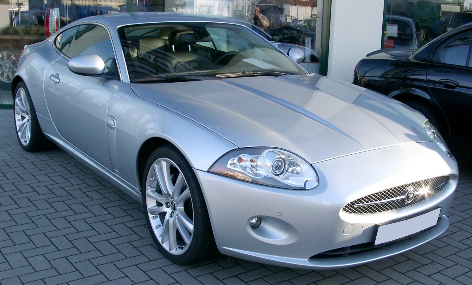 Silver luxury sports coupe with distinctive headlights and sleek aerodynamic design
