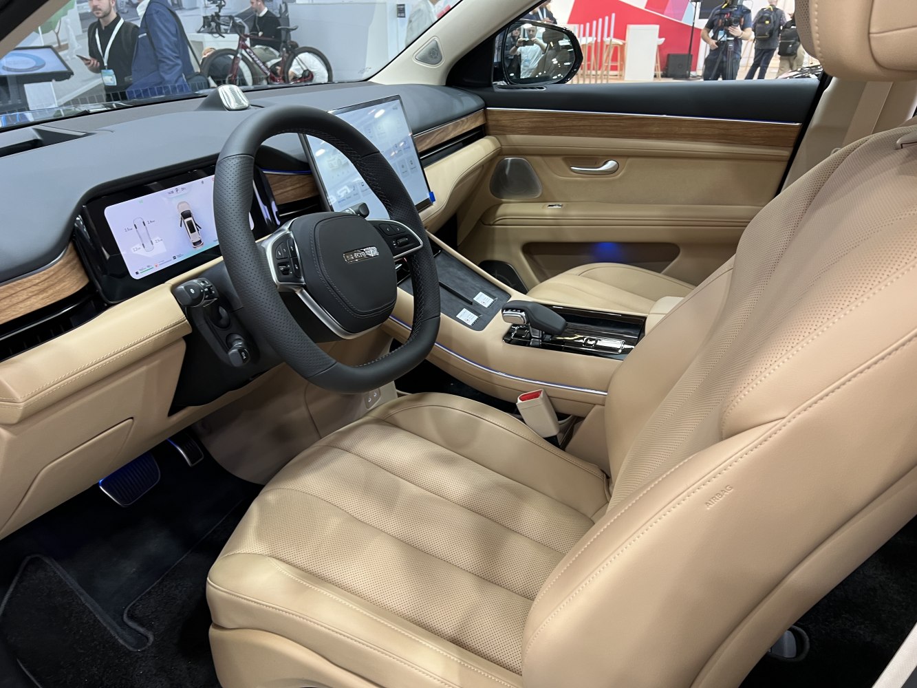 Beige leather seats with wood trim and digital dashboard display