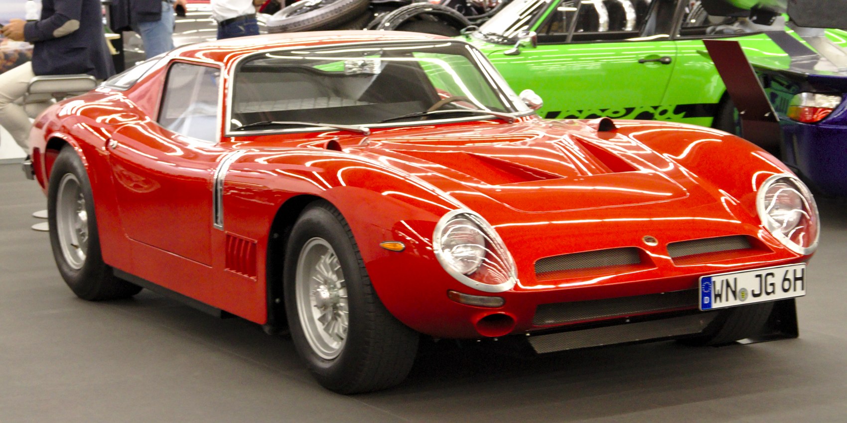 Red aerodynamic vintage sports coupe with round headlights and classic wheels
