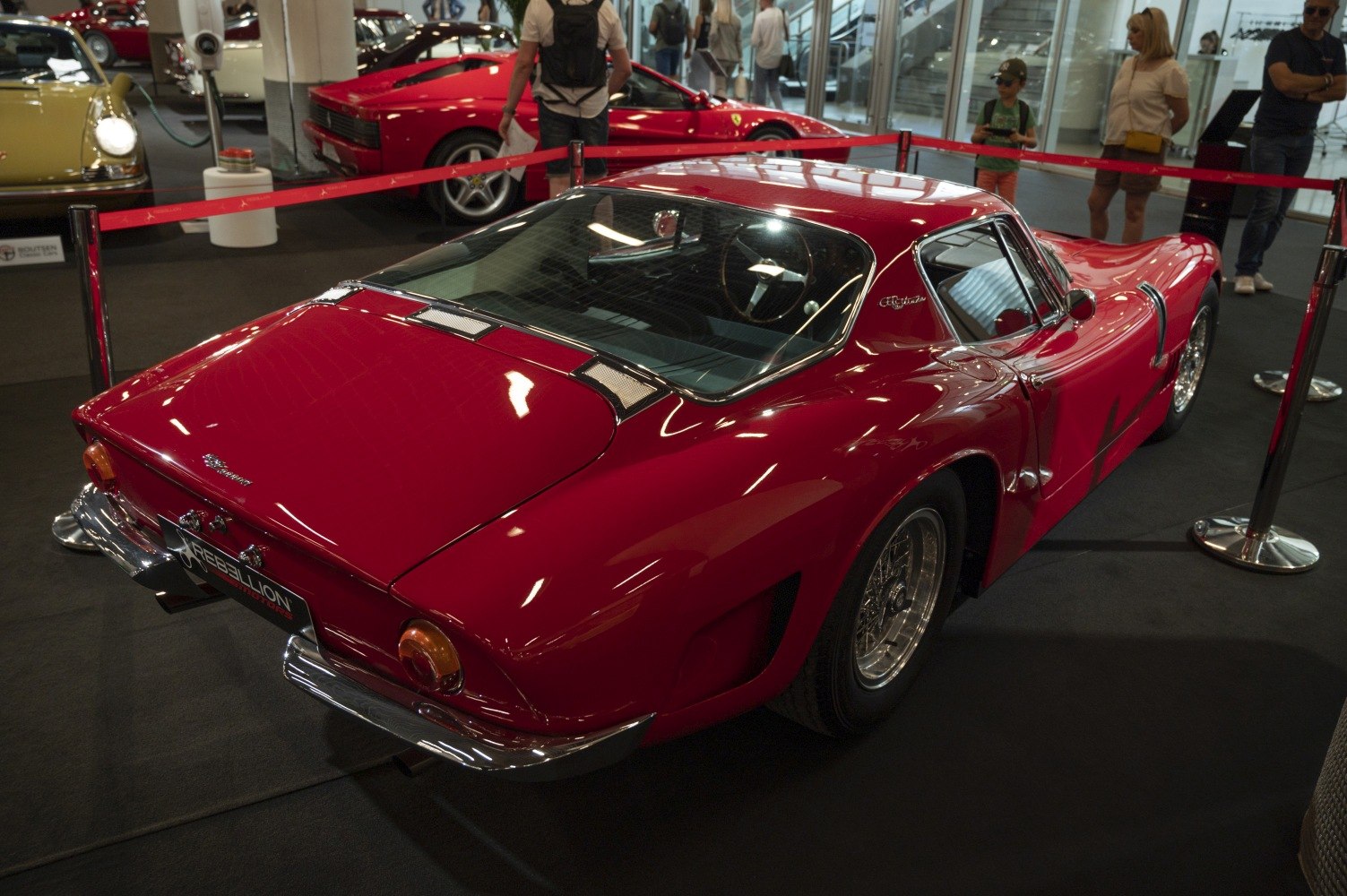 Red vintage sports coupe with expansive rear window and curved body.