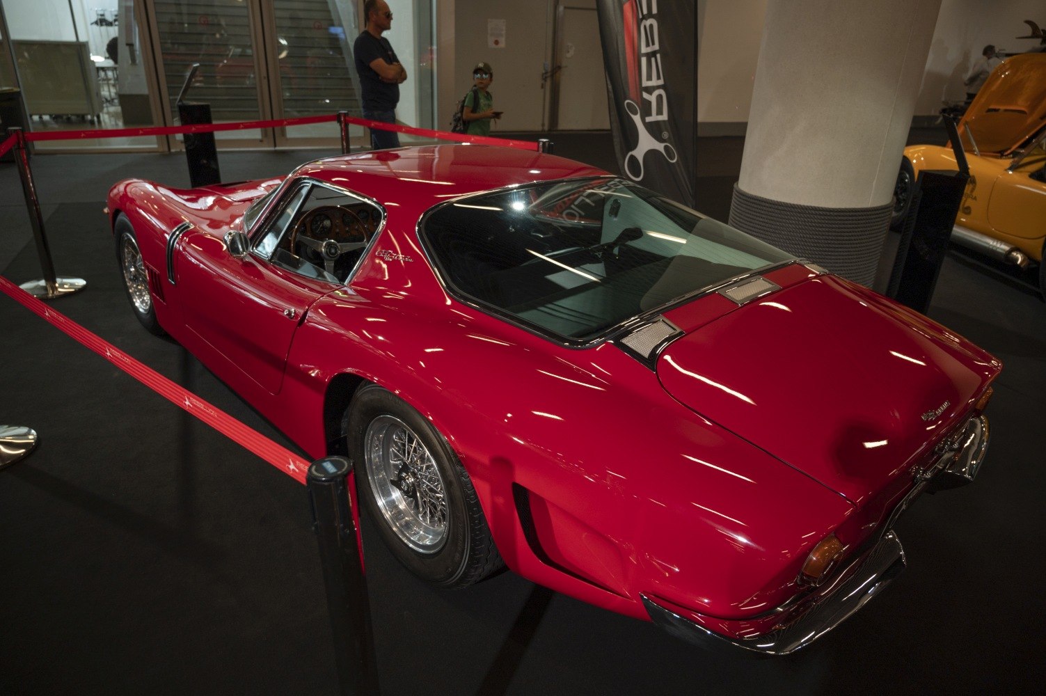 Vintage red sports coupe with sleek rear design and wire wheels