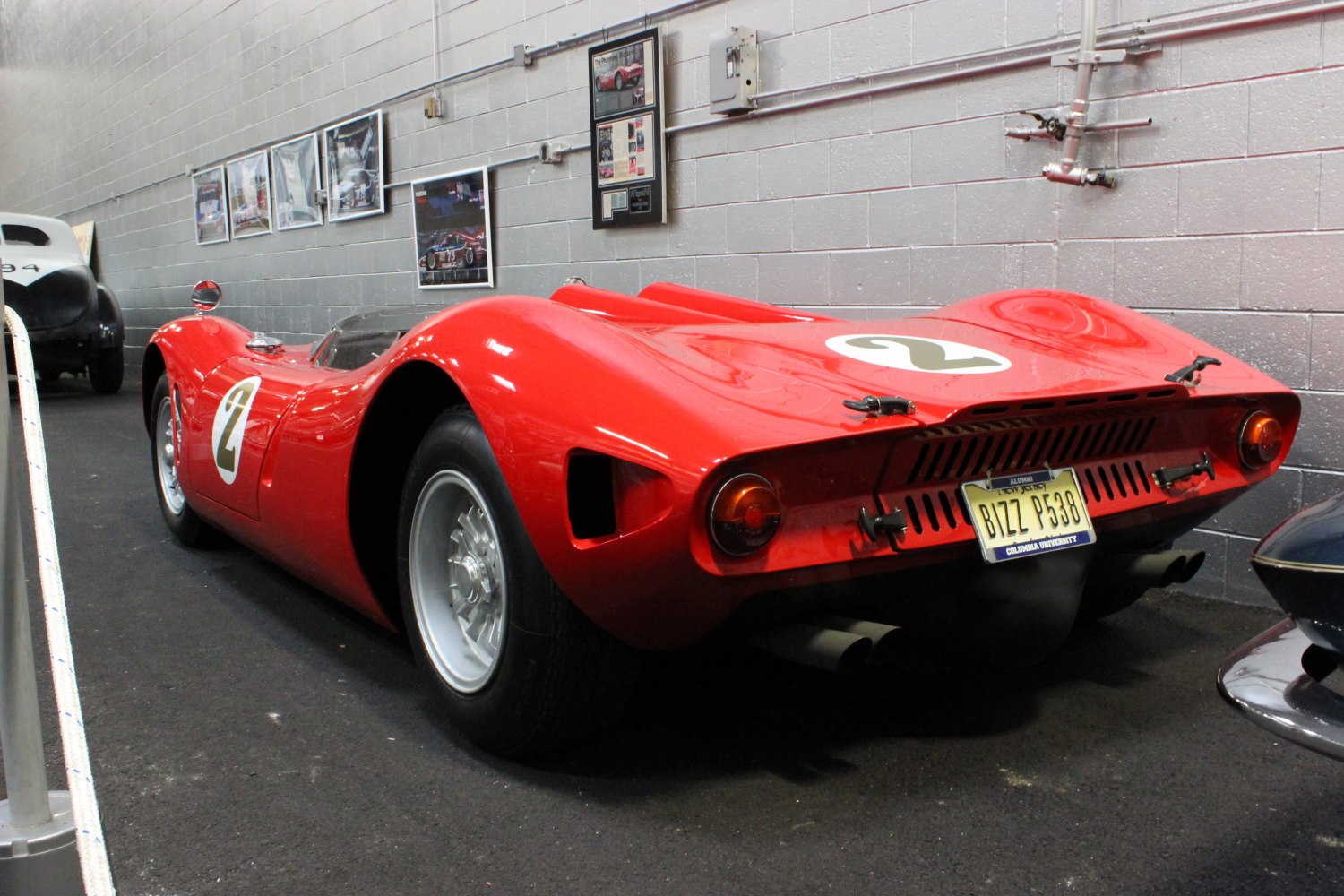 Vintage red race car with streamlined body and dual rear exhaust