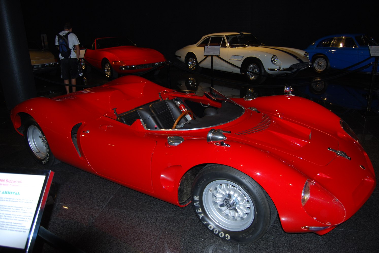 Red open-top racing prototype with mid-60s aerodynamic design and alloy wheels