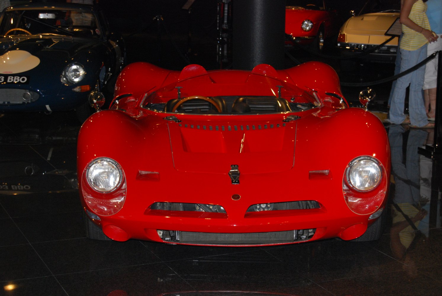 Red race car front with dual round headlights and open cockpit