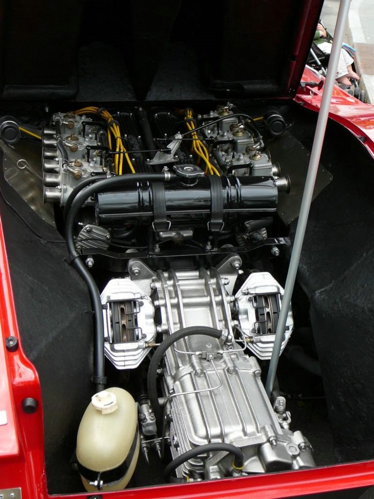 Close-up of vintage car engine and transmission with visible carburetors and mechanical parts