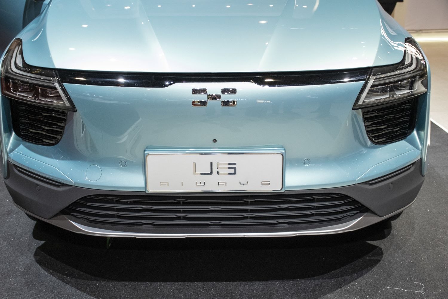 Front grille and headlight close-up of blue electric SUV.