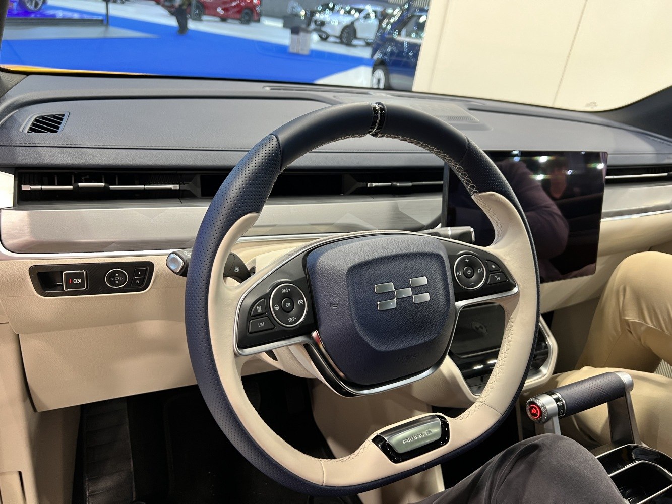 Steering wheel and dashboard with touchscreen and controls.