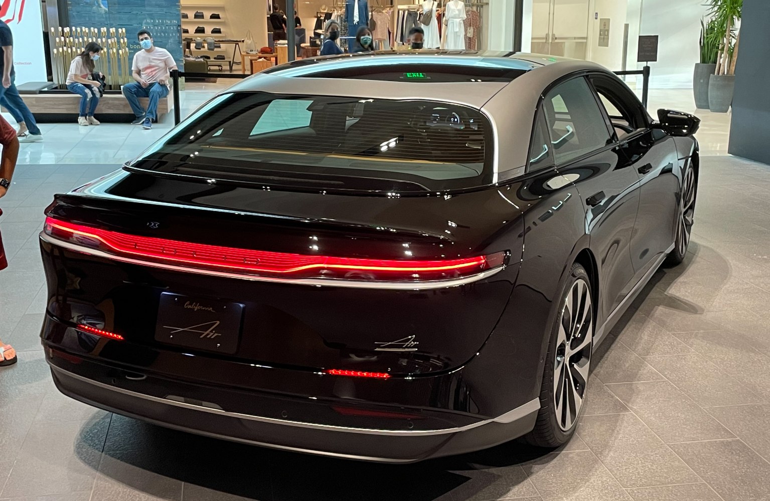 Rear view of electric luxury sedan with LED light bar and panoramic rear window