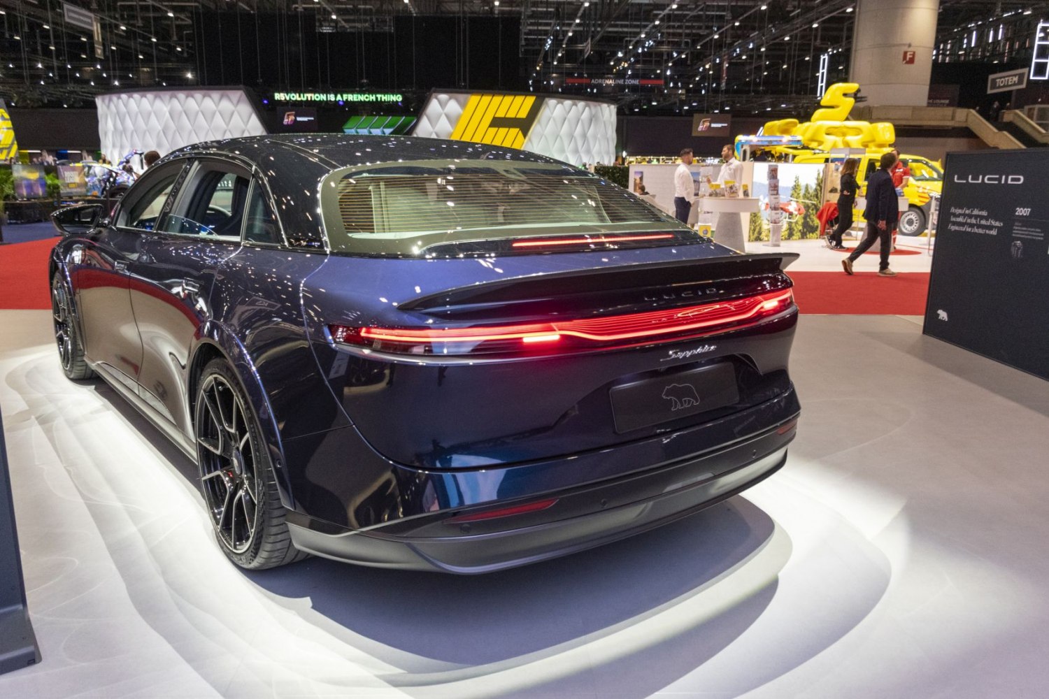 Rear view of a luxury electric sedan with sleek LED tail light bar and aerodynamic design