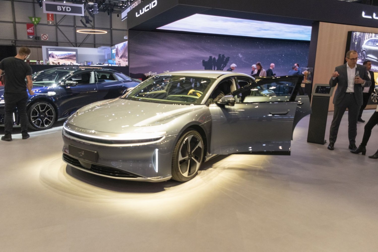 Electric sedan with aerodynamic front and side profile, one door open.
