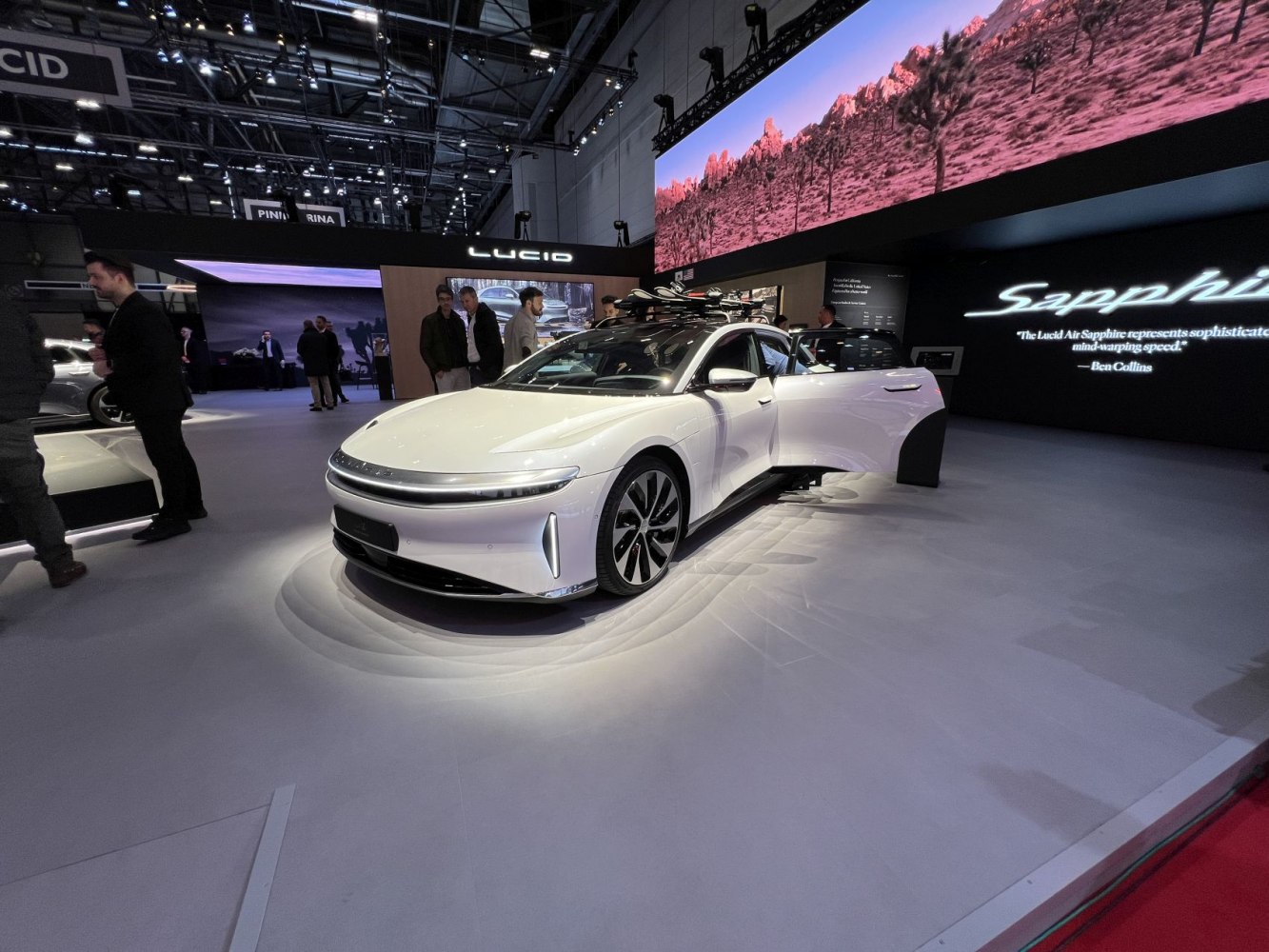 Sleek electric luxury sedan with roof rack and distinctive LED lighting