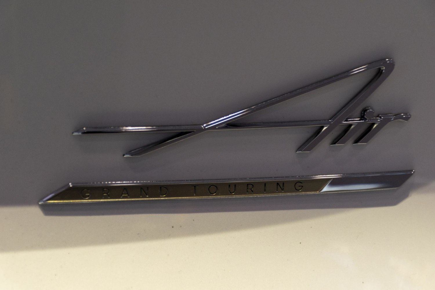 Chrome Grand Touring emblem with stylized Air script