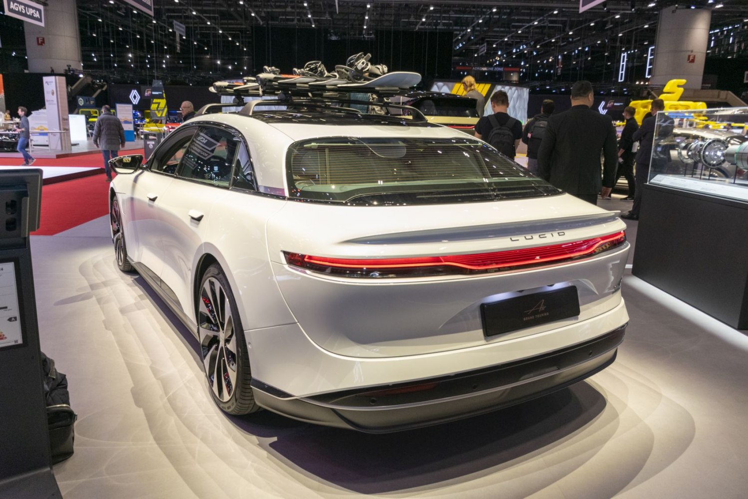 Rear view of electric sedan with roof snowboard rack.