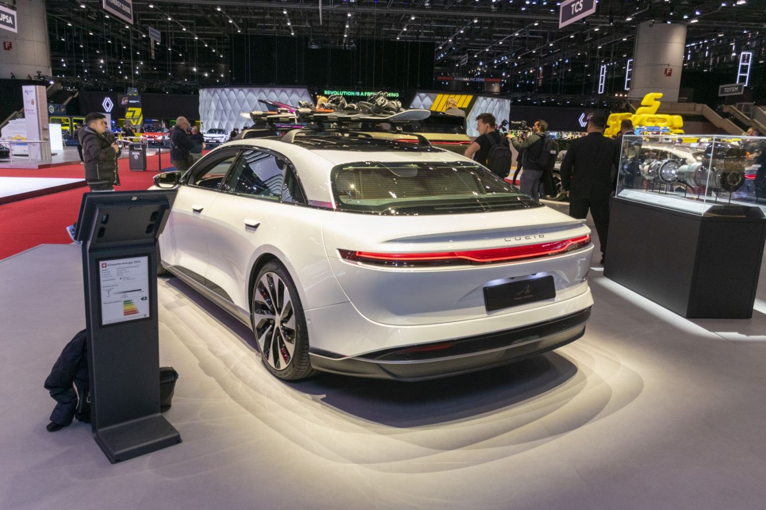 Rear view of electric luxury sedan with roof rack and taillights.