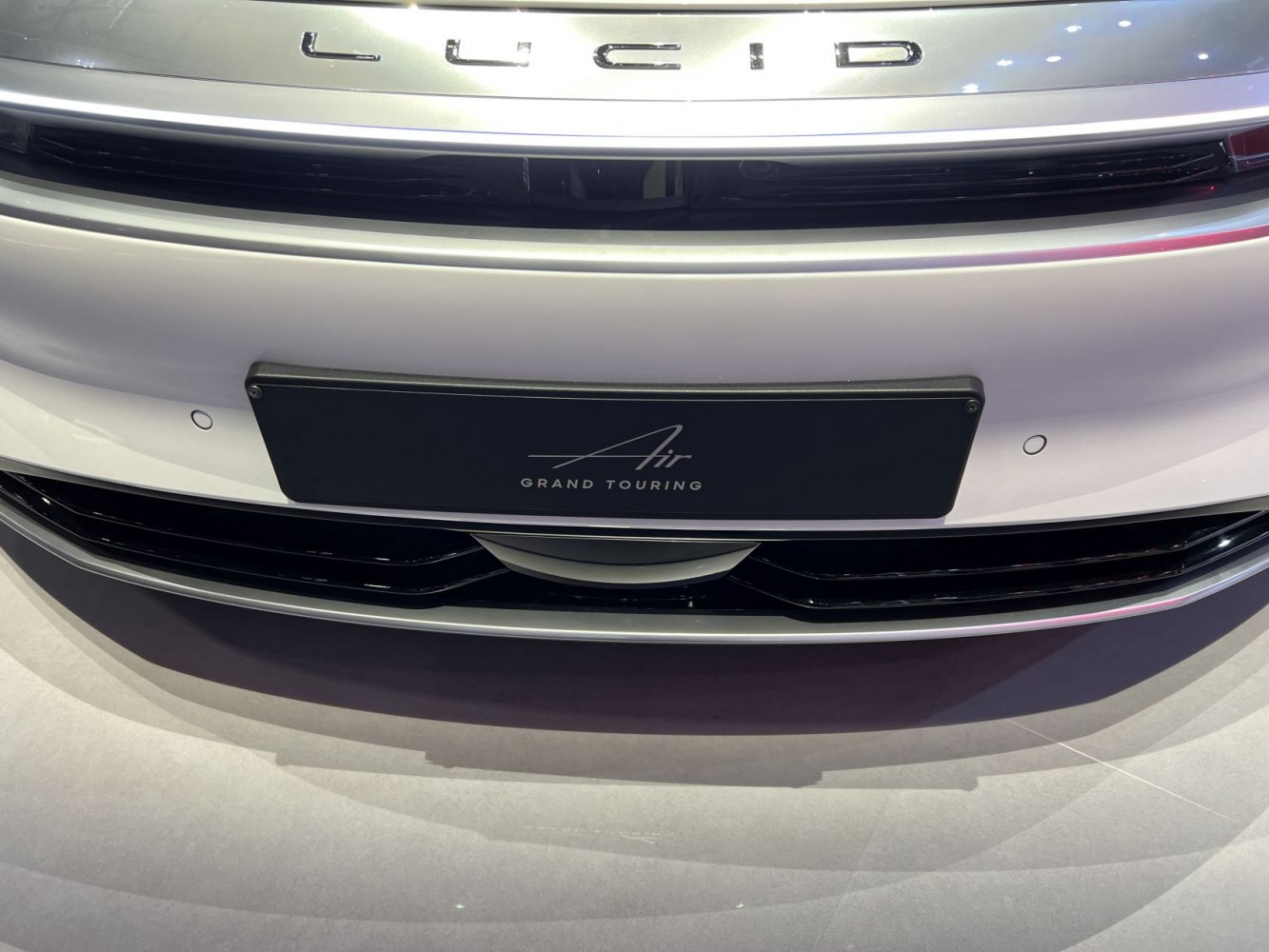 Close-up of front grille and badge with 'Air Grand Touring' plate