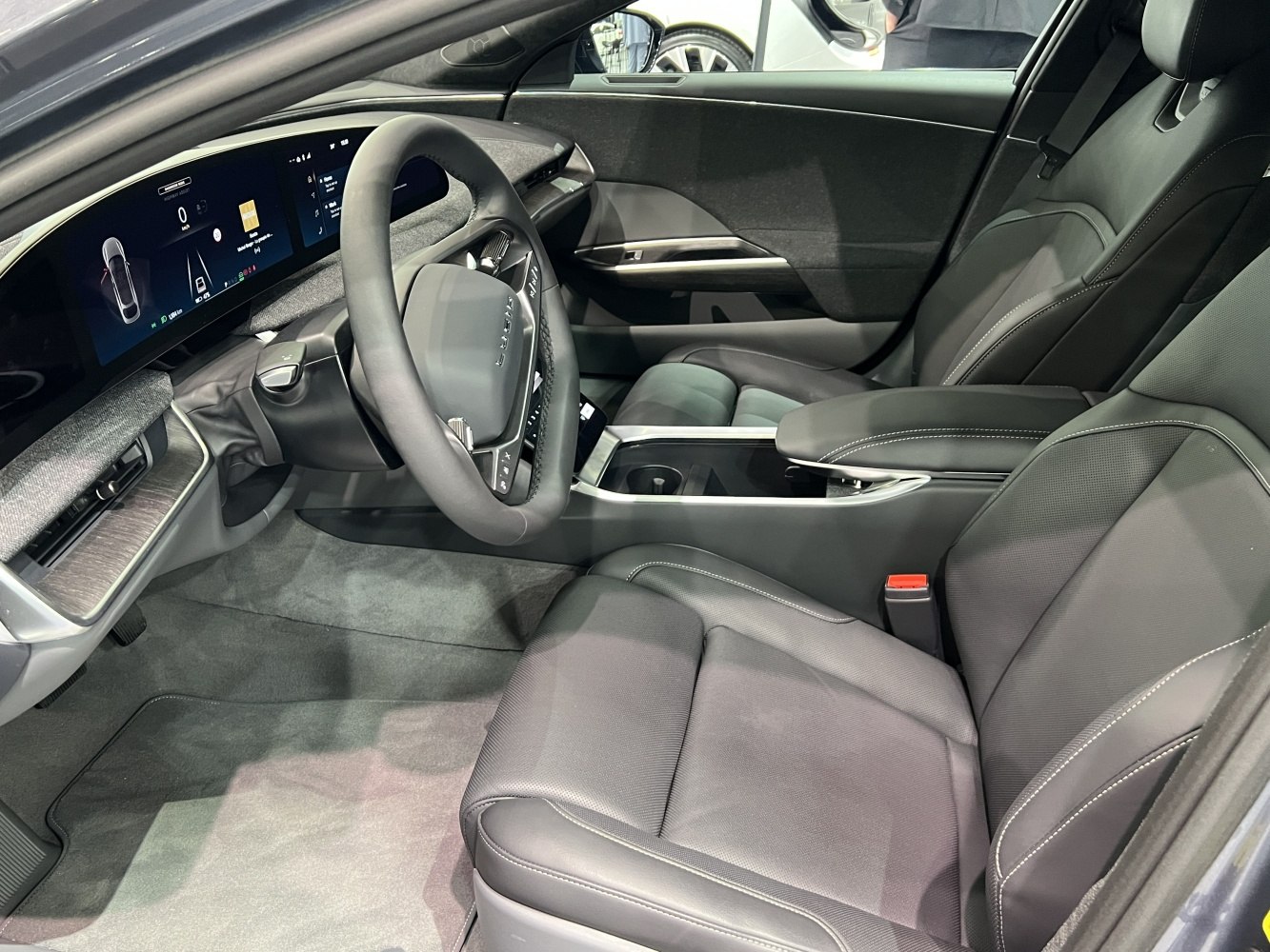 Widescreen digital dashboard and ergonomic front seats in a modern electric vehicle interior.