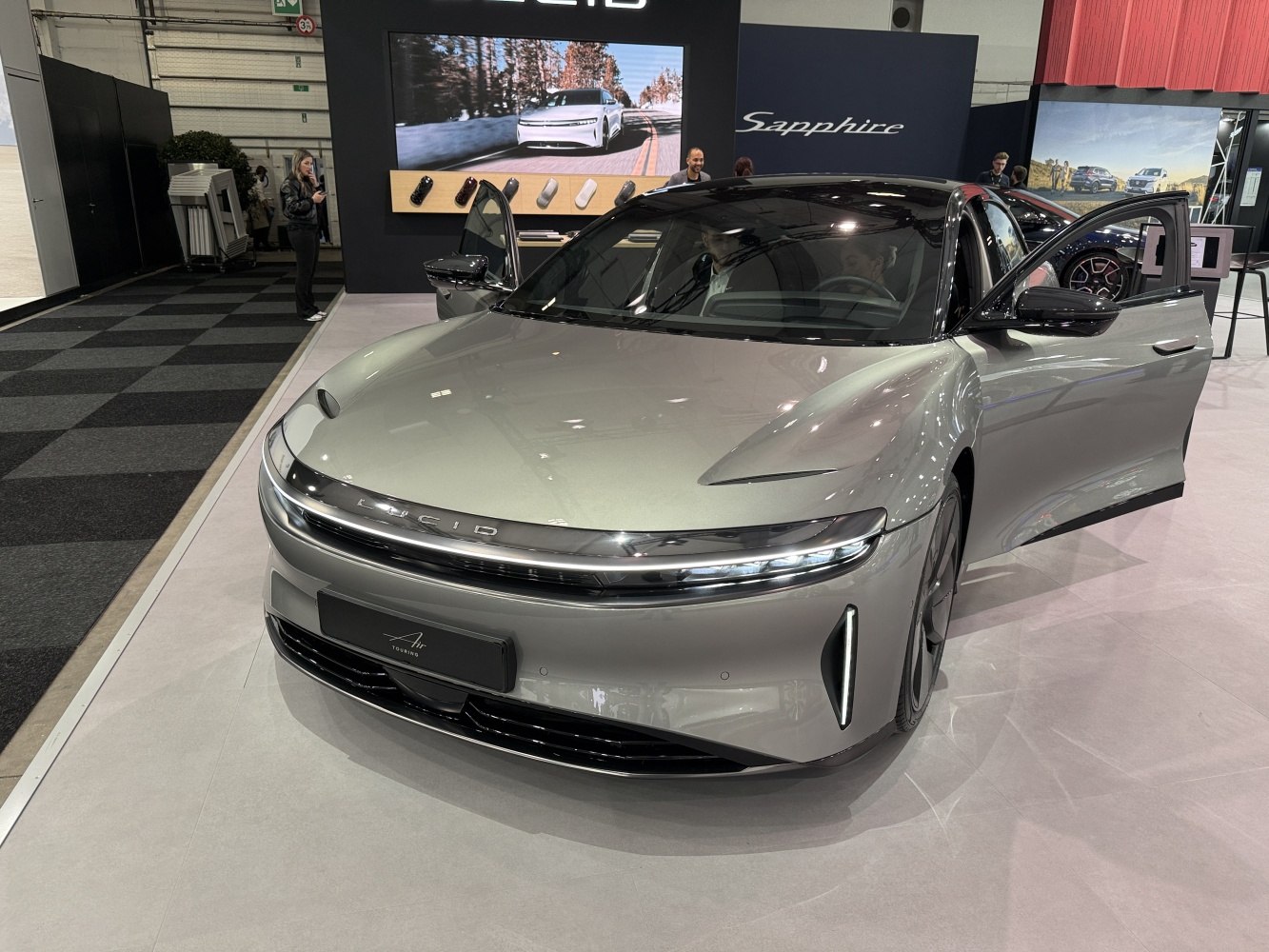 Sleek front with LED strip lighting and glossy hood on electric sedan