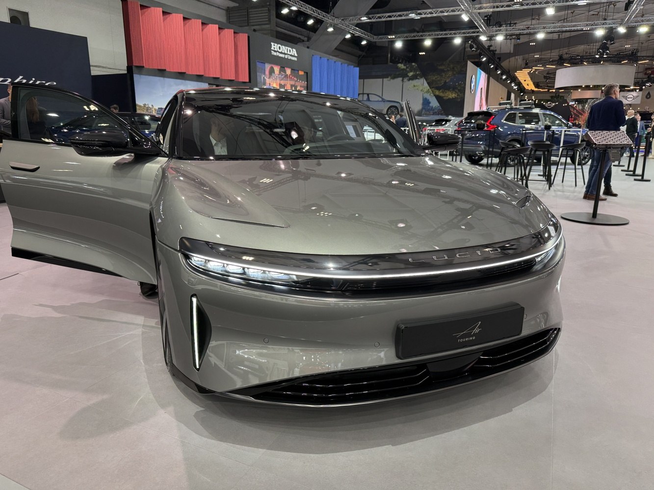 Front view of a sleek electric sedan with slim LED headlights and aerodynamic design.