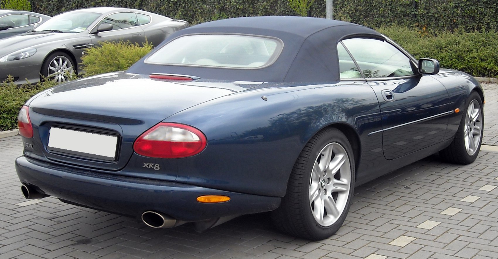 Rear view of a convertible with soft top roof and dual exhaust pipes
