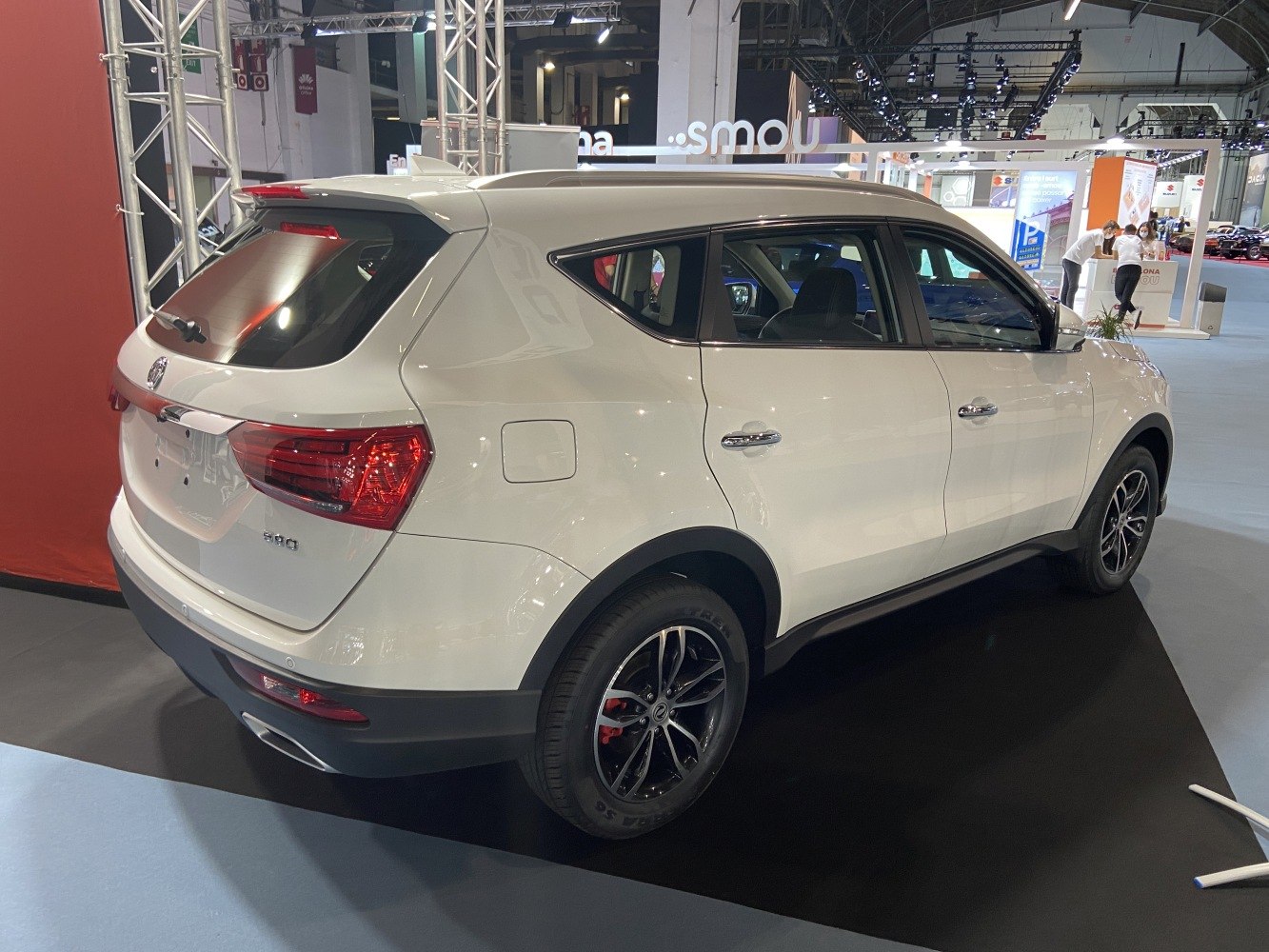 White SUV rear side with alloy wheels and roof spoiler