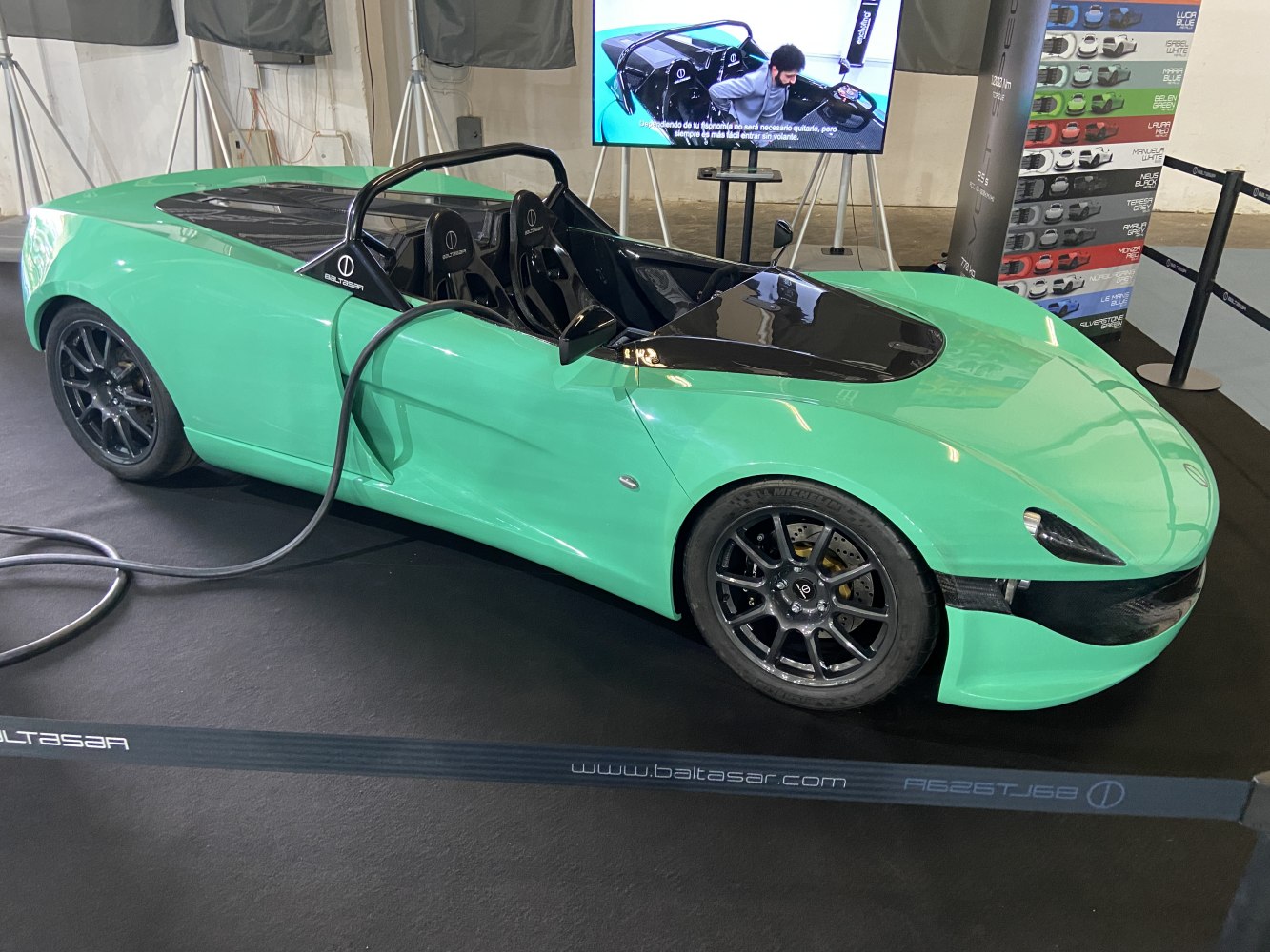 Electric roadster charging, open-top sleek aerodynamic design