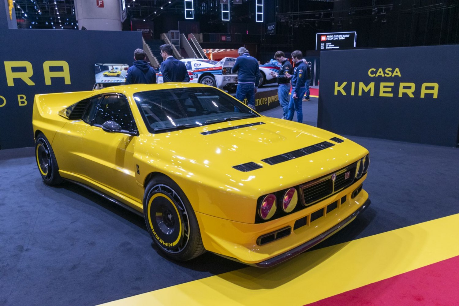 Yellow retro sports coupe with aero features, hood vents, and unique wheel rims